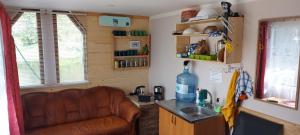 uma cozinha com um sofá e um lavatório num quarto em Pirts,kubls,,Saknēs,, em Talsi