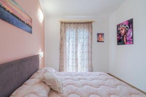 ein Schlafzimmer mit einem großen Bett und einem Fenster in der Unterkunft Casa Iole Portopalo in Portopalo