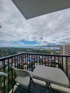 a balcony with a white chair and a view of a city at Condo Hotel near Mactan Cebu Airport in Mactan