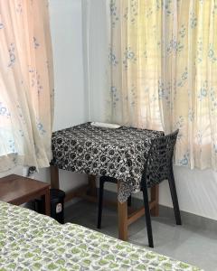 a table in a room with a bed and curtains at Sanctuary View Homestay Thattekad in Ernakulam +55 photos