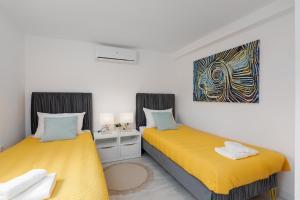 a bedroom with two beds and a painting on the wall at Apartman Grey in Slunj