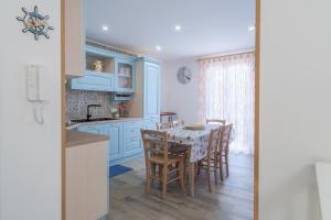 eine Küche mit blauen Schränken und einem Tisch mit Stühlen in der Unterkunft Casa Iole Portopalo in Portopalo