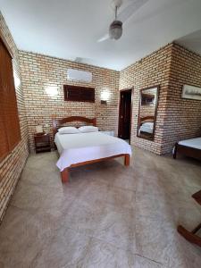 a bedroom with a bed and a brick wall at Pousada Solar das Fontes in Beberibe +37 photos