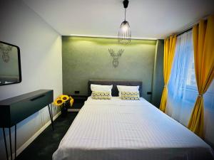 a bedroom with a large bed with yellow curtains at Central Place to Stay in Reşiţa