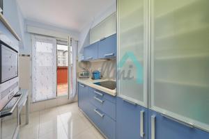 una cocina con armarios azules y fregadero en Ático Salesas, en Oviedo