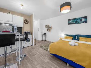 a bedroom with a bed and a desk and a kitchen at Studio enchanté avec terrasse in Luce