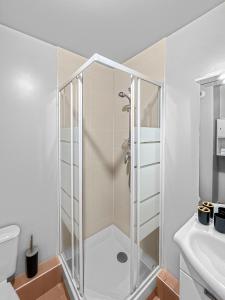 a shower with a glass door in a bathroom at Studio enchanté avec terrasse in Luce