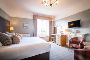 a hotel room with a bed and a television at Ambleside Townhouse in Ambleside