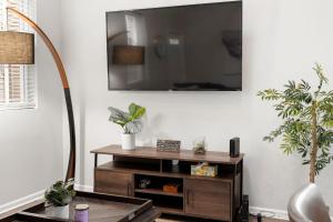 un soggiorno con TV a parete e piante di Chicago Treasure 4 Bed Getaway a Chicago