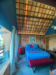 ein Schlafzimmer mit einem Bett mit Holzdecke in der Unterkunft Chalé Por do Sol in Caruaru