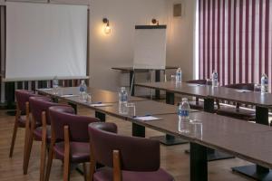 een kamer met tafels en stoelen met flessen water erop bij Best Western White House Hotel in Watford