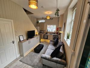 a living room with a couch and a kitchen at Carlisle Central, Cute Studio Appt, The Cupboard in Carlisle