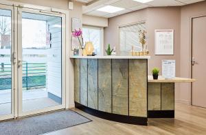 a lobby with a counter and a window at Hôtel Restaurant Bel Air Crevin - Axe Rennes Nantes in Crévin