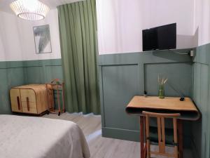 1 dormitorio con cama, mesa y TV en Albergo Mango, en Francavilla in Sinni