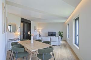 uma sala de estar com uma mesa e cadeiras e um sofá em Ola Living Paseo de Gracia em Barcelona