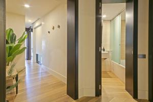 Un pasillo de una casa con un baño con espejo. en Ola Living Paseo de Gracia, en Barcelona 49 fotos más