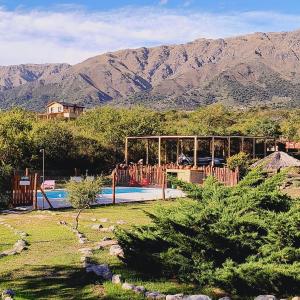 a pool in a yard with mountains in the background at San Luis Aparts in Carpintería