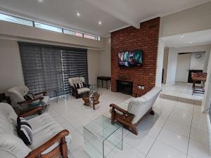uma sala de estar com sofás e uma lareira de tijolos em 2 Bedroom Private Retreat em Bloemfontein