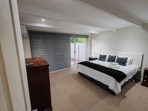 um quarto com uma cama e uma porta de vidro deslizante em 2 Bedroom Private Retreat em Bloemfontein