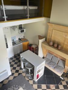 a small kitchen with a table and a stool at Chez Nanou, à proximité de St Emilion in Sainte-Terre