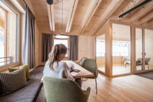 uma mulher sentada numa mesa numa sala em Die Lecherin em Lech am Arlberg