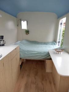 1 dormitorio con cama y ventana. en Gezellige en frisse pipowagen bij Zutphen en IJssel, en Vierakker