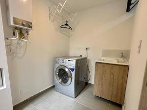 a laundry room with a washer and a sink at Casa Campestre con Piscina Cerca al Parque del Café in La Tebaida