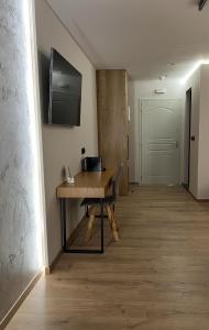 pasillo con mesa de madera y TV en la pared en Morfeas Hotel, en La Canea