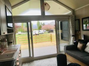 a living room with a sliding glass door with a view of a yard at Self-Catering Lodge with Hot Tub in Inverness +7 photos