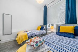 twee bedden in een kamer met blauw en geel bij Townhead in Kirkintilloch