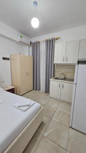 Vila Finnley في كساميل: غرفة بسرير ومطبخ مع ثلاجة