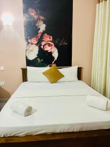 1 cama con 2 almohadas y una pintura en la pared en Airport City Hotel en Katunayaka