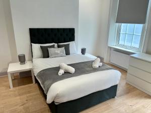 a bedroom with a large bed with two towels on it at Kings Cross Guest House in London