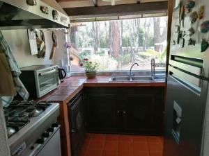a kitchen with a stove and a sink and a window at Casa Helichrysum in Fort Village