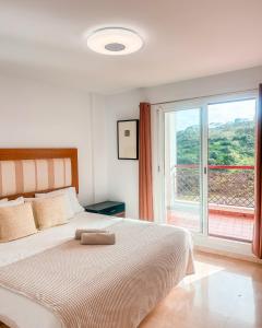 1 dormitorio con cama y ventana grande en Albatross Golf Suite Alcaidesa, en Alcaidesa