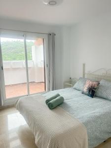 um quarto com uma cama grande e uma janela grande em Albatross Golf Suite Alcaidesa em La Alcaidesa