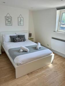 Un dormitorio con una gran cama blanca con animales de peluche. en Kings Cross Guest House, en Londres