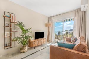 a living room with a tv and a large window at Seaflower Torrox Costa in Torrox Costa
