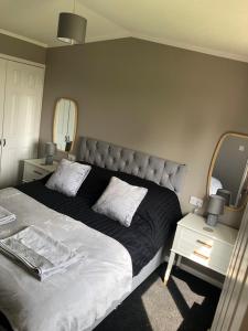 a bedroom with a large bed and a tv at Spacious Lodge With Hot Tub in Lincolnshire