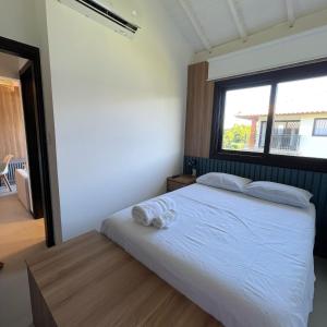 a bedroom with a white bed with a window at Mykonos Praia do Forte in Praia do Forte +23 photos