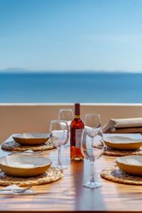 Vári的住宿－Lalari Beach Suites，一张桌子,上面放着眼镜和一瓶葡萄酒