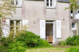 Plobannalec-LesconilにあるPetite maison plage 5min en voitureの白いドアと窓のある古い家