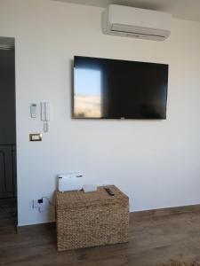 a flat screen tv on a white wall with a box at Donna Carmela in Porticello