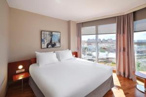 a bedroom with a large bed and a large window at Eurostars Don Cándido in Terrassa