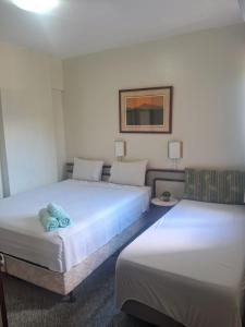 two beds in a hotel room with two beds at FLAT FUNCIONAL e ECONÔMICO,CENTRO-GO in Goiânia