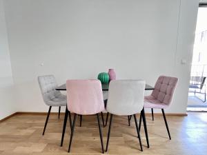 stół jadalny z 4 krzesłami i wazonem w obiekcie Funky Apartment near Central Station Free Parking w Wiedniu