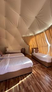 een slaapkamer met 2 bedden in een tent bij Wadi Rum desert magic in Wadi Rum