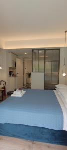 Cette chambre comprend un grand lit bleu et une cuisine. dans l'établissement MUSES LUXURY SUITES, à Corfou