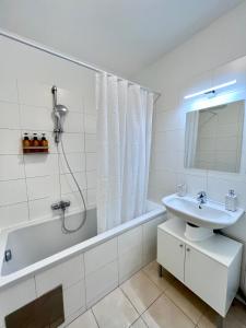 łazienka z wanną, umywalką i prysznicem w obiekcie Funky Apartment near Central Station Free Parking w Wiedniu