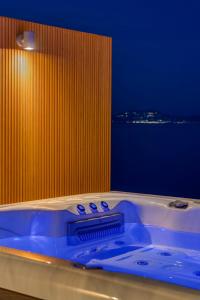a bath tub with a view of the ocean at Lalari Beach Suites in Vari